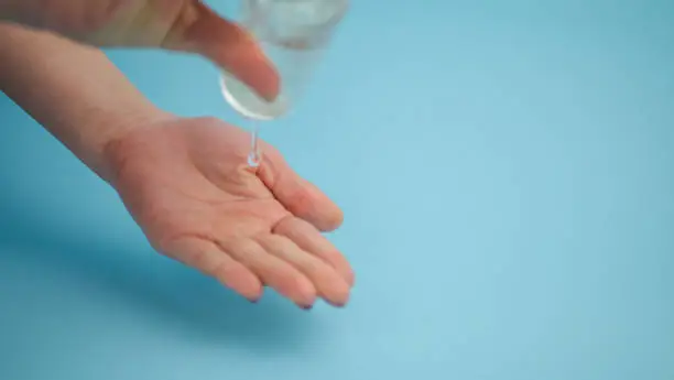 Photo of Human hand plastic bottle using alcohol gel to do the cleaning. isolated blue background. coronavirus in 2019 will stop the outbreak. copy space