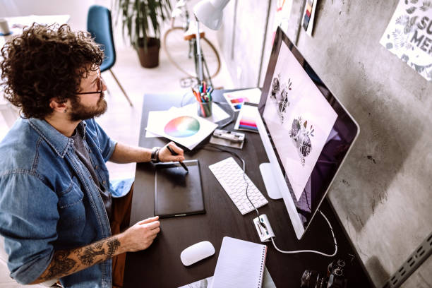 Digital Artist Working At Home Handsome Young Man Working In Comfort of His Home graphic designer stock pictures, royalty-free photos & images