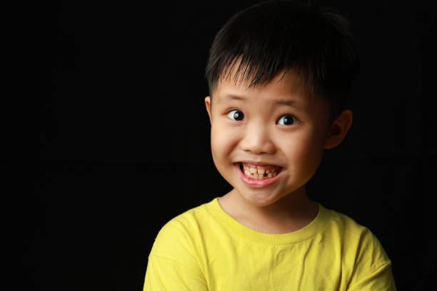 Portrait of little Asian boy on black background