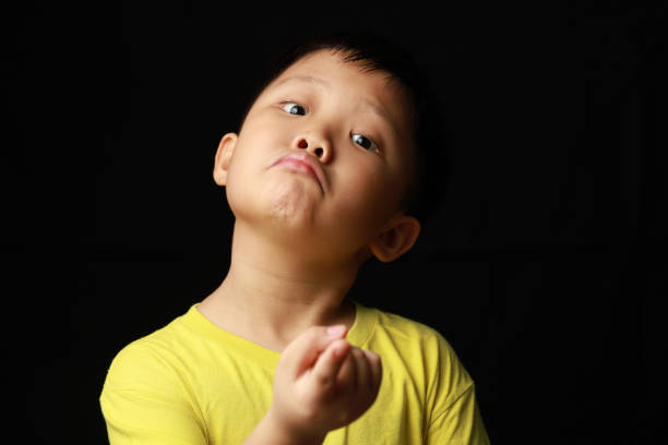 Portrait of a young boy yawning on white background.