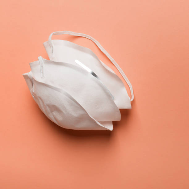 istock Anti coronavirus Covid-19 protective mask on orange background 1213784733