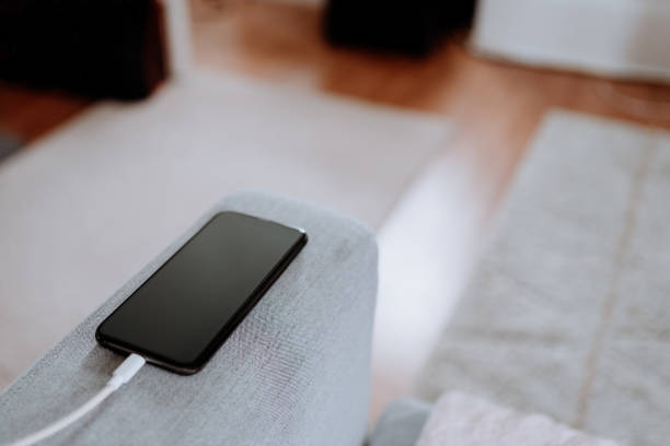 istock Cell phone being charged at home 1213788143