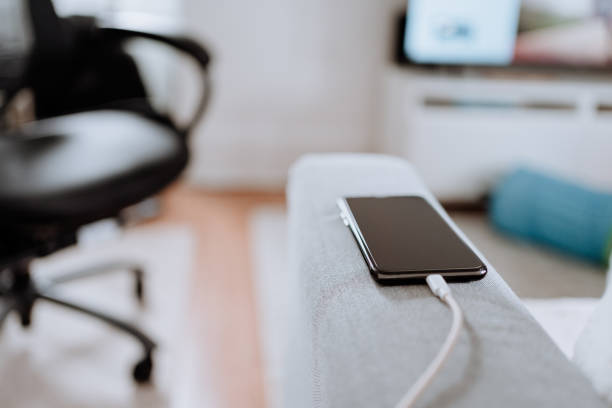 istock Cell phone being charged at home 1213788149