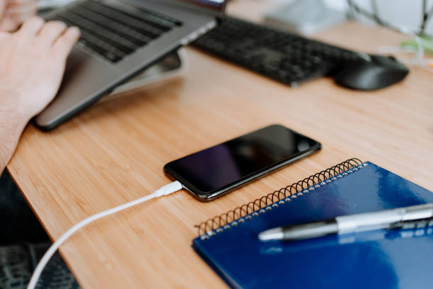 Man charging his cellphone in home office