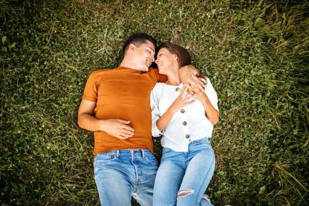 istock Loving young couple lying on the grass by the river 1213791797
