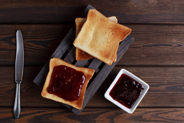 istock Toasts with jam on dark wooden table 1213791978