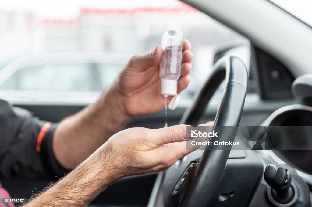 Mann mit Handdesinfektionsmittel, während im Auto sitzen - Lizenzfrei Handdesinfektionsmittel Stock-Foto