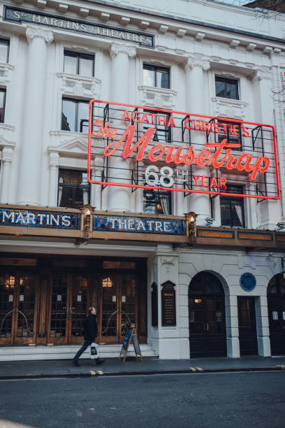 człowiek przechodzący obok neonu pułapka na myszy na fasadzie st martins theatre w londynie, wielka brytania. - agatha christie zdjęcia i obrazy z banku zdjęć