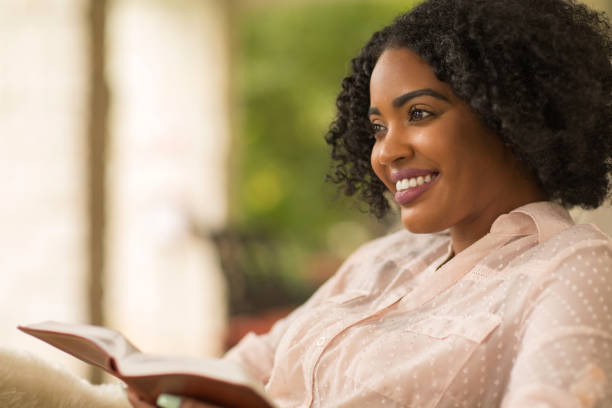 istock Woman smiling holding a book. 1213801667