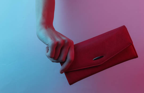 istock Female hand holds a leather wallet. Creative pop art pink blue neon color. Trendy gradient illumination. Night light 1213801941