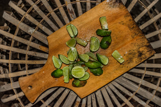lime sliced on wooden cutting board stock photo