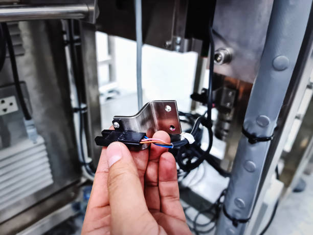 istock Hand Holding Stainless Steel Bracket and Wired Sensor for Automated Machine 1213803649