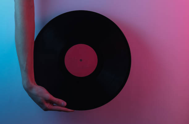 istock Retro wave 80s. Hands holding vinyl record. Creative pop art pink blue neon color. Trendy gradient illumination. Night light 1213804900