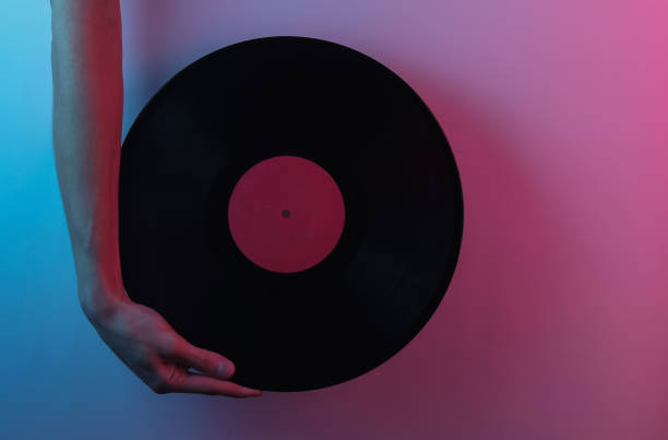 retro fala lat 80-tych. ręce trzymające płytę winylową. kreatywny pop-art różowy niebieski neonowy kolor. modne oświetlenie gradientowe. światło nocne - record turntable disc jockey pop art zdjęcia i obrazy z banku zdjęć