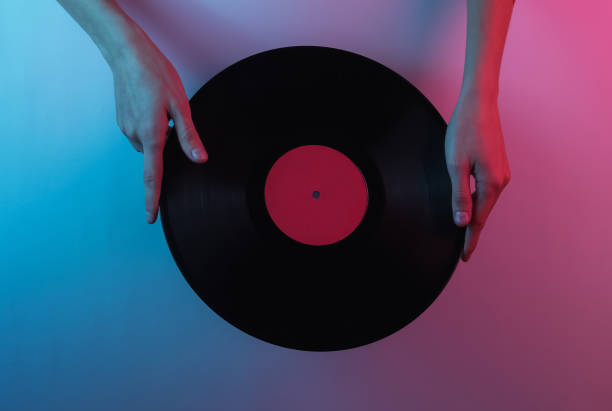 istock Retro wave 80s. Hands holding vinyl record. Creative pop art pink blue neon color. Trendy gradient illumination. Night light 1213804906
