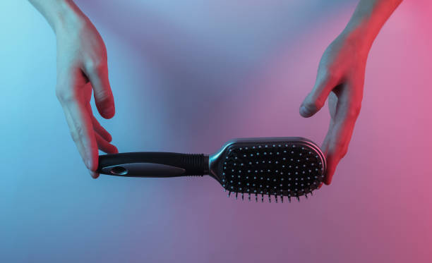istock Hands holding hair comb. Creative pop art pink blue neon color. Trendy gradient illumination. Night light 1213805438