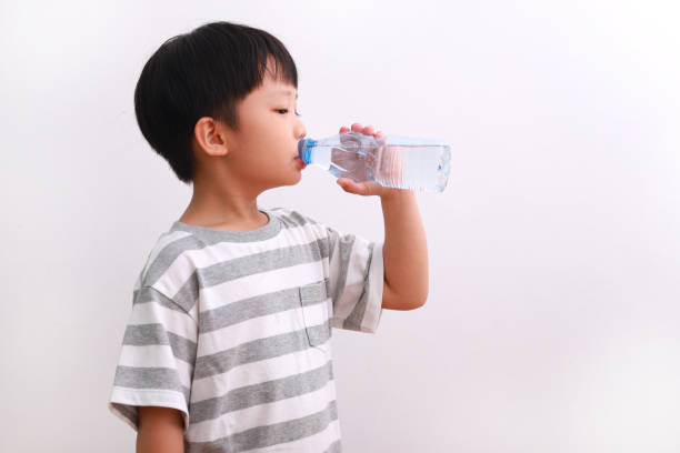 istock Little Boy Holding Drinking Water Against White Background 1213805775
