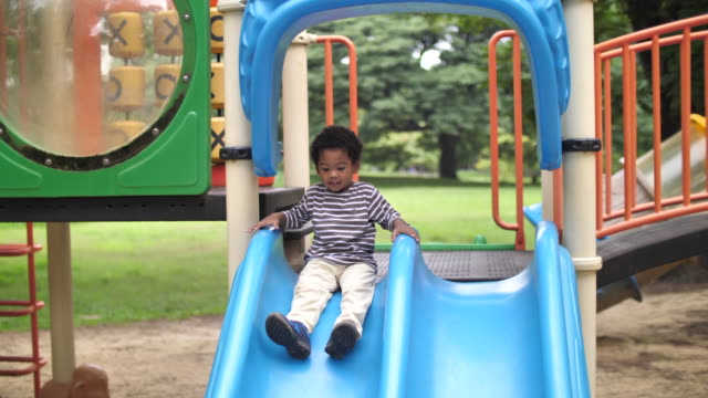 African Boy at Playground sliding down