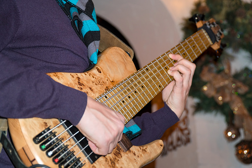 The bass player plays a five-string bass guitar close-up. Plays bass guitar. Selective focus