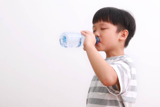 istock Little Boy Holding Drinking Water Against White Background 1213808527