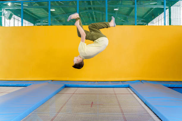 Teenage boy jumping on trampoline park in sport center Teenage boy jumping on trampoline park in a sport center trampoline stock pictures, royalty-free photos & images