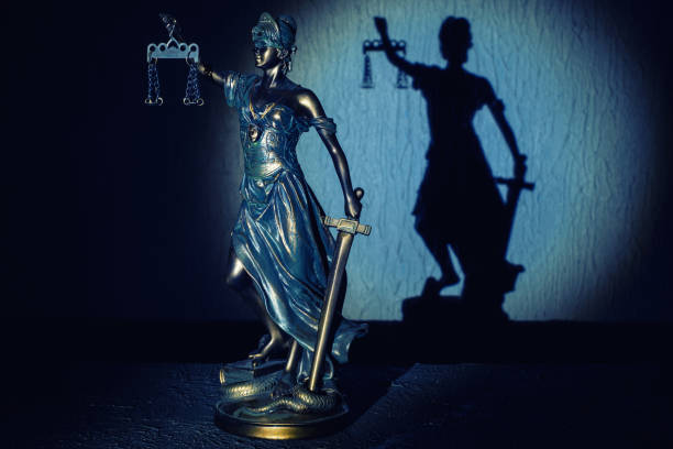 la statuetta di themis si erge sul vecchio tavolo in pietra d'epoca. - justice is blind foto e immagini stock