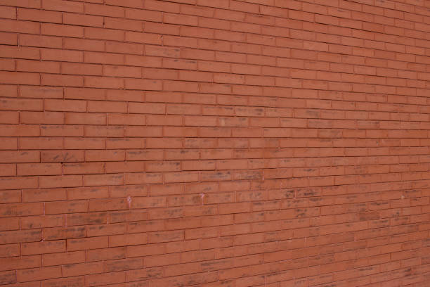 istock Older burnt orange color brick wall texture background with scuffed and stained surface 1213813451