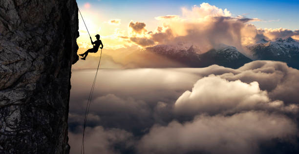 istock Silhouette of a Unrecognizable man rappelling down a steep cliff 1213813841
