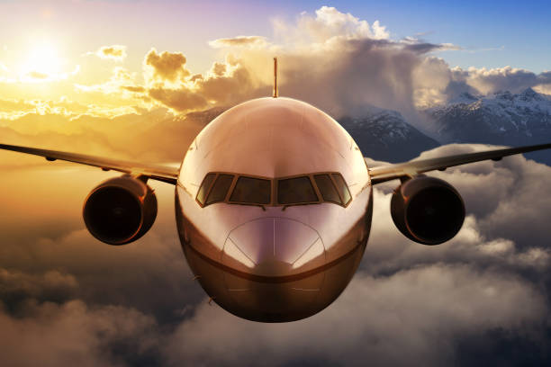 Airplane flying above the clouds Airplane flying above the clouds during colorful sunset or sunrise. Concept of Travel, transportation, aviation, journey, adventure wow airlines stock pictures, royalty-free photos & images