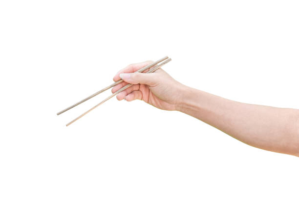 istock hand holding wooden chopsticks isolated on white background with clipping path. 1213816799