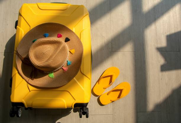 istock Summer traveler accessories with empty space for text. Travel vacation concept. Summer background.   Yellow Suitcase on wooden background 1213817057