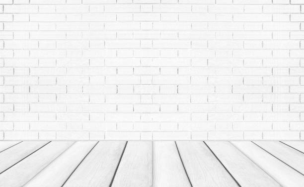 istock White empty wooden floors with brick wall background. Studio or office blank space. 1213817738
