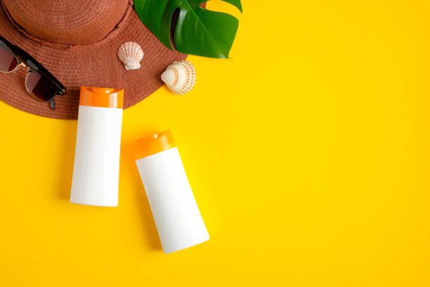 istock Sunscreen lotion in white plastic bottles, beach hat and tropical leaf on yellow background. Sun protection, sunblock cosmetic product, summer skin care concept. Flat lay, top view 1213817975
