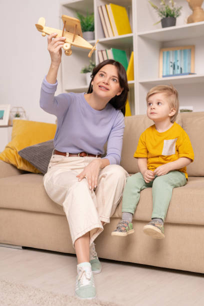 istock Mother showing son how to fly plane 1213821079
