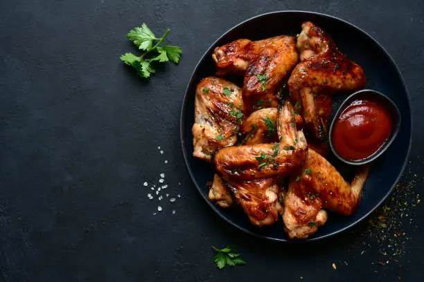 Photo of Grilled spicy chicken wings with ketchup