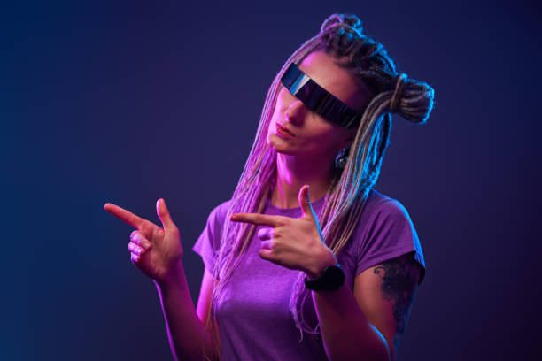 istock Girl in sunglasses looking at camera in neon light 1213825368