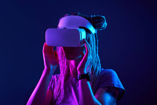 istock Woman is using virtual reality headset. Neon light studio portrait. 1213825384
