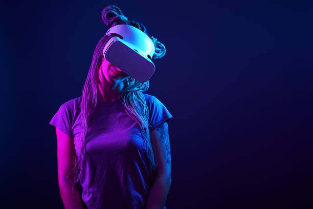 istock Woman is using virtual reality headset. Neon light studio portrait. 1213825392