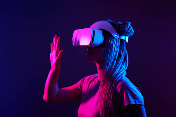 istock Woman is using virtual reality headset. Neon light studio portrait. 1213825424