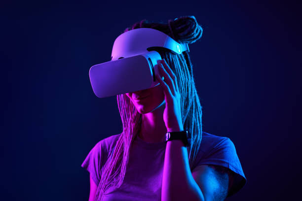 istock Woman is using virtual reality headset. Neon light studio portrait. 1213825824