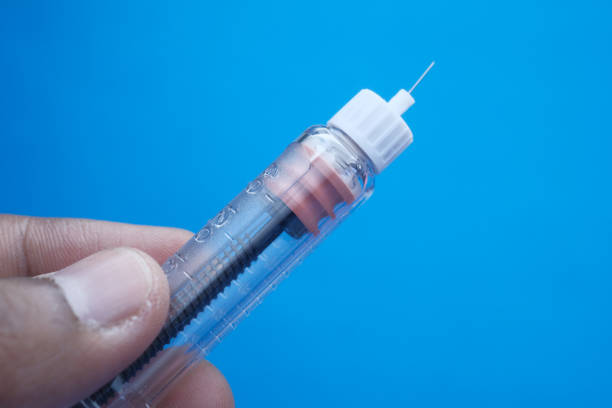 istock hand holding Insulin injection pen on color background 1213826648