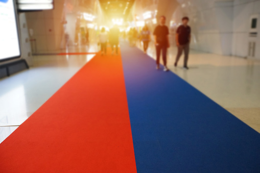 Blurry image of visitor walk along mat flow of exhibition hall with sun ray effect