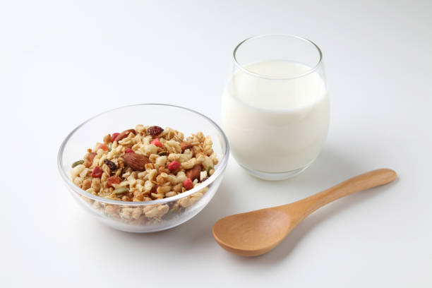 granola cereal in bowl with milk isolated on white background