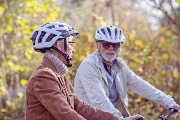istock Senior couple with bycicles and helmets in park 1213829044