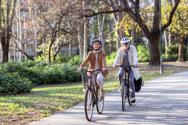 istock Senior couple with bycicles and helmets in park 1213829046