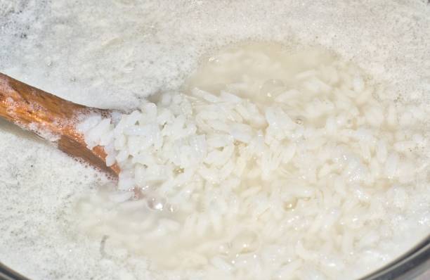 istock White rice boiling in frothy water in a saucepan. 1213829352