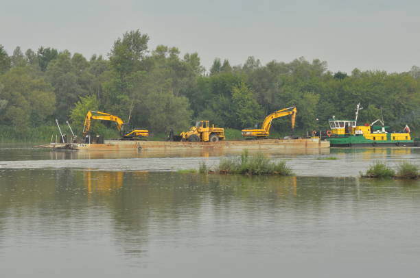 istock Sell construction and vehicles transported by river barge, with a high water level in the river. 1213830137