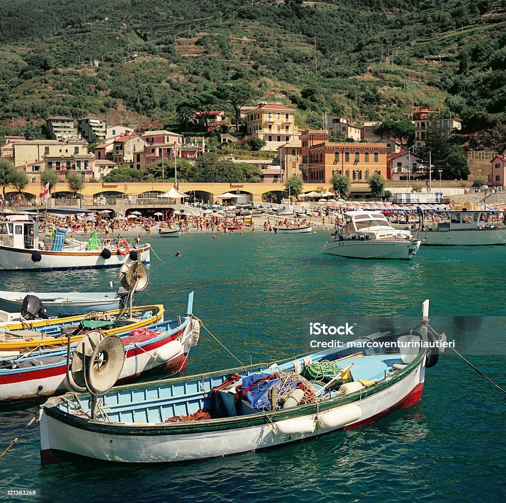 Monterosso - iconic summer landmark with boats and houses Monterosso, Cinque Terre, Liguria, Italy, as seen from the harbour. Focus on the fishing boat.  Cinque Terre Stock Photo