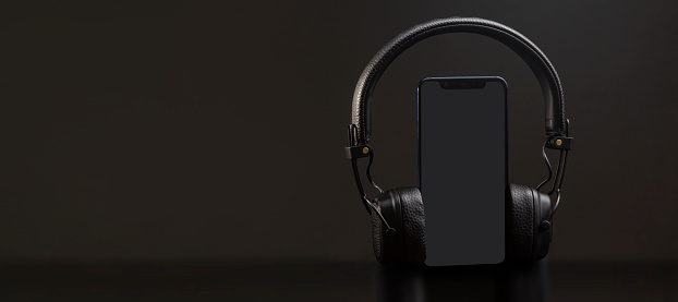 black headphones on smartphone music online concept, mockup