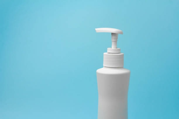 istock Mock up of white bottle with a dispenser on a blue background. Copy space for advertisement for cosmetic product. 1213833249